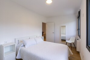 2 dormitorios y tabla de planchar con plancha