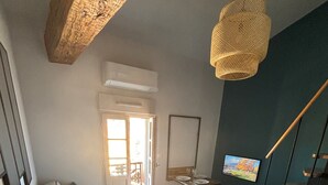 Una sala moderna con un sofá, una mesa de comedor y una zona de cocina.