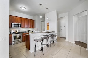 - Fully equipped kitchen with stainless steel appliances & stylish wooden cabinetry
- Convenient breakfast bar with seating for three, perfect for casual meals or morning coffee
- Bright & airy, with modern pendant lighting to enhance the ambiance