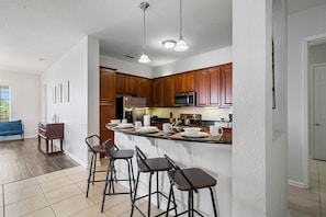 - Contemporary kitchen design with a focus on functionality and aesthetics
- Breakfast bar setup creates a seamless flow into the living and dining areas
- Welcoming space to gather, cook, and enjoy quality time together