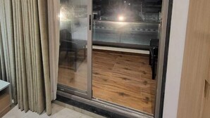 A room with a sliding glass door leading to an outdoor area with a wooden deck.