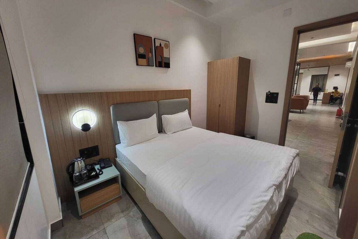 Ein Hotelzimmer mit Bett, Nachttisch und Kleiderschrank.