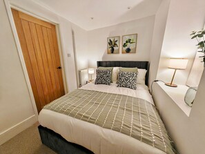 A neatly arranged bedroom with a bed, two bedside lamps, and a door. - Prime Exeter Stay for Corporate & Family Guests (Exeter)