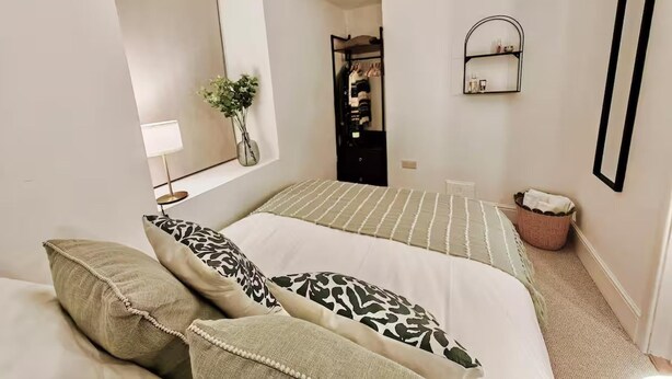 A bedroom with two beds, a mirror, a small shelf, and a potted plant. - Prime Exeter Stay for Corporate & Family Guests (Exeter)