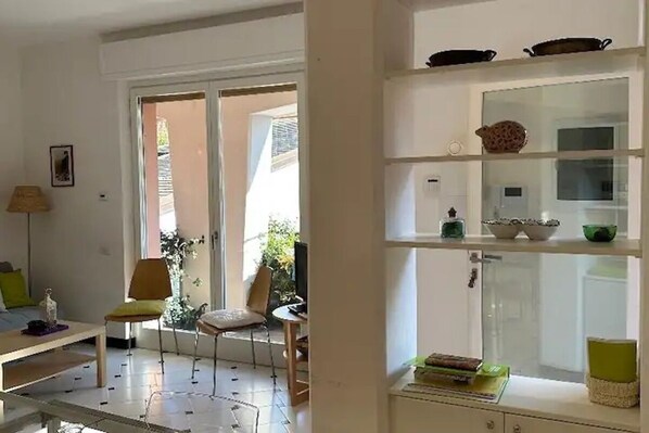 A living room with a sofa, chairs, a coffee table, and a glass cabinet with decorative items.