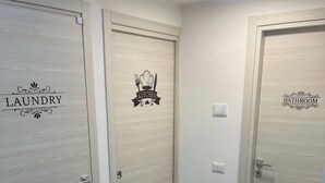 A hallway with three doors labeled 'Laundry', 'Kitchen', and 'Bathroom'.
