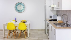 A modern kitchen with white cabinets, a stainless steel sink, and a microwave.