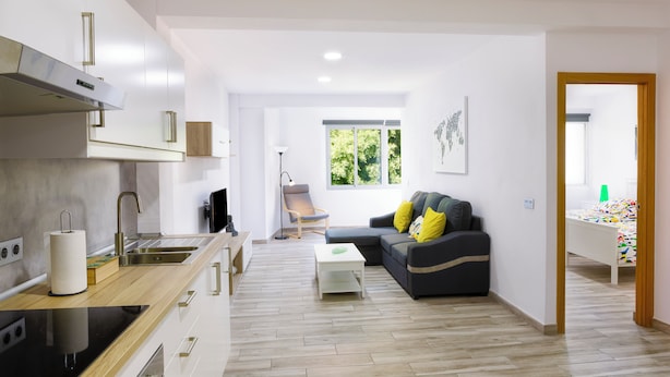 A modern apartment with a kitchen, living room, and a small dining area.