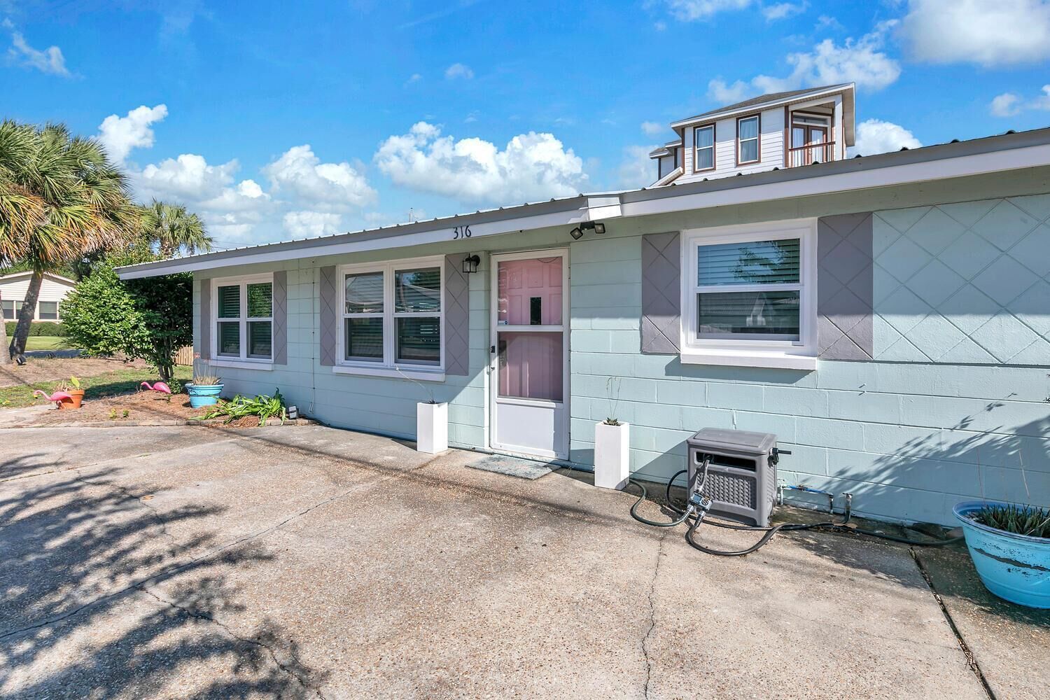 Einbungalow mit Garage, einer kleinen Veranda und einem Fenster mit Fensterläden.