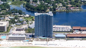 Ein Hochhaus-Hotel mit Innenhof, in Strandnähe und an einem Gewässer gelegen.
