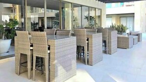 An outdoor seating area with wicker furniture and large windows. - Casa El Encanto Priv Rooftop With Tub Best Loc (El Tezal)