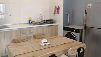 Refrigerador, placa de cocina, utensilios de cocina, mesa de comedor