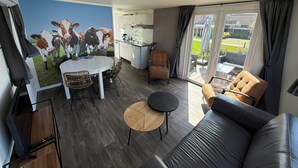 Una sala moderna con un sofá grande, una mesa de comedor y una zona de cocina.