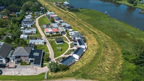 Vista aérea de una zona residencial con casas, un lago y una carretera.