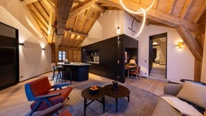 Amplia sala de estar con techo alto, vigas de madera, cocina y comedor.