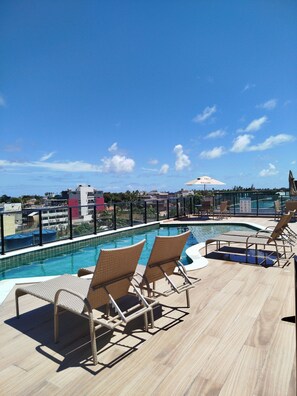 A rooftop pool area with lounge chairs and a view of the cityscape. - Porto City - Porto de Galinhas (Ipojuca)