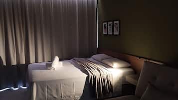Ein Hotelzimmer mit einem Bett, einer Couch und einem an der Wand befestigten Fernseher.