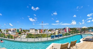 A swimming pool with a view of a cityscape, including buildings and a clear sky. - Porto City - Porto de Galinhas (Ipojuca)