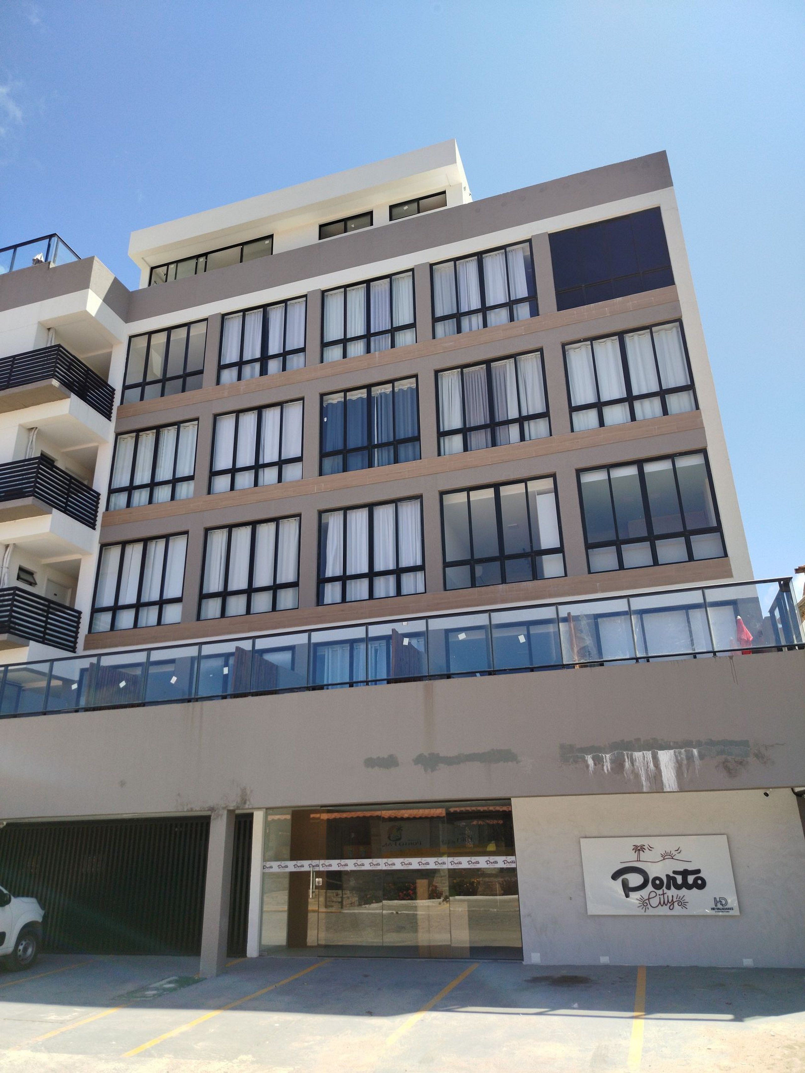 Um edifício de vários andares com design arquitetônico moderno, com grandes janelas e varandas.