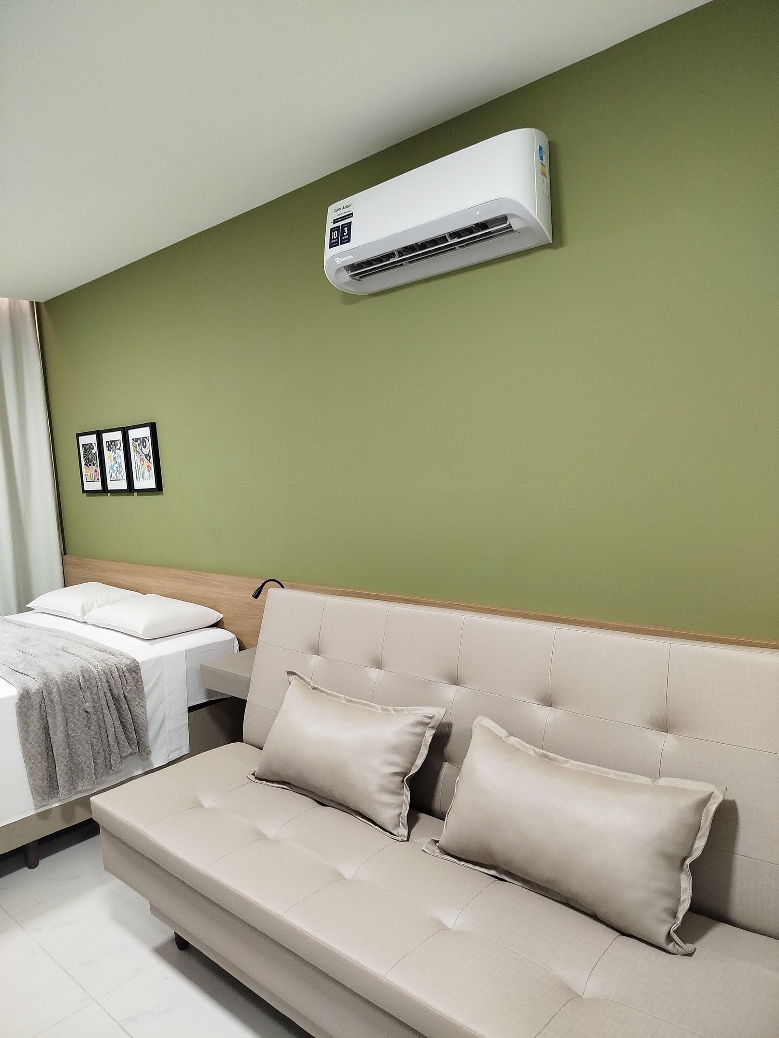 Une chambre d’hôtel équipée d’un lit, d’un canapé et d’un climatiseur fixé au mur.