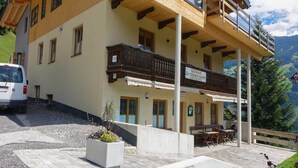 Un bâtiment à deux étages doté d’un balcon, d’une enseigne indiquant « GASHAUS » et d’un espace extérieur aménagé pour s’asseoir.