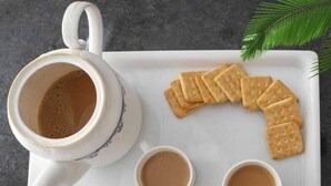 A white tray with a teapot, two cups of coffee, and several biscuits. - Shree Ji Kunj (Udaipur)