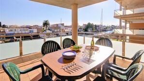 Comedor con una mesa preparada para cuatro, con vista a un puerto deportivo lleno de barcos.