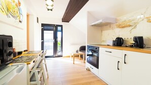 A modern kitchen with a wooden countertop, a built-in oven, and a coffee maker. - Ben Apartments (Sibiu)