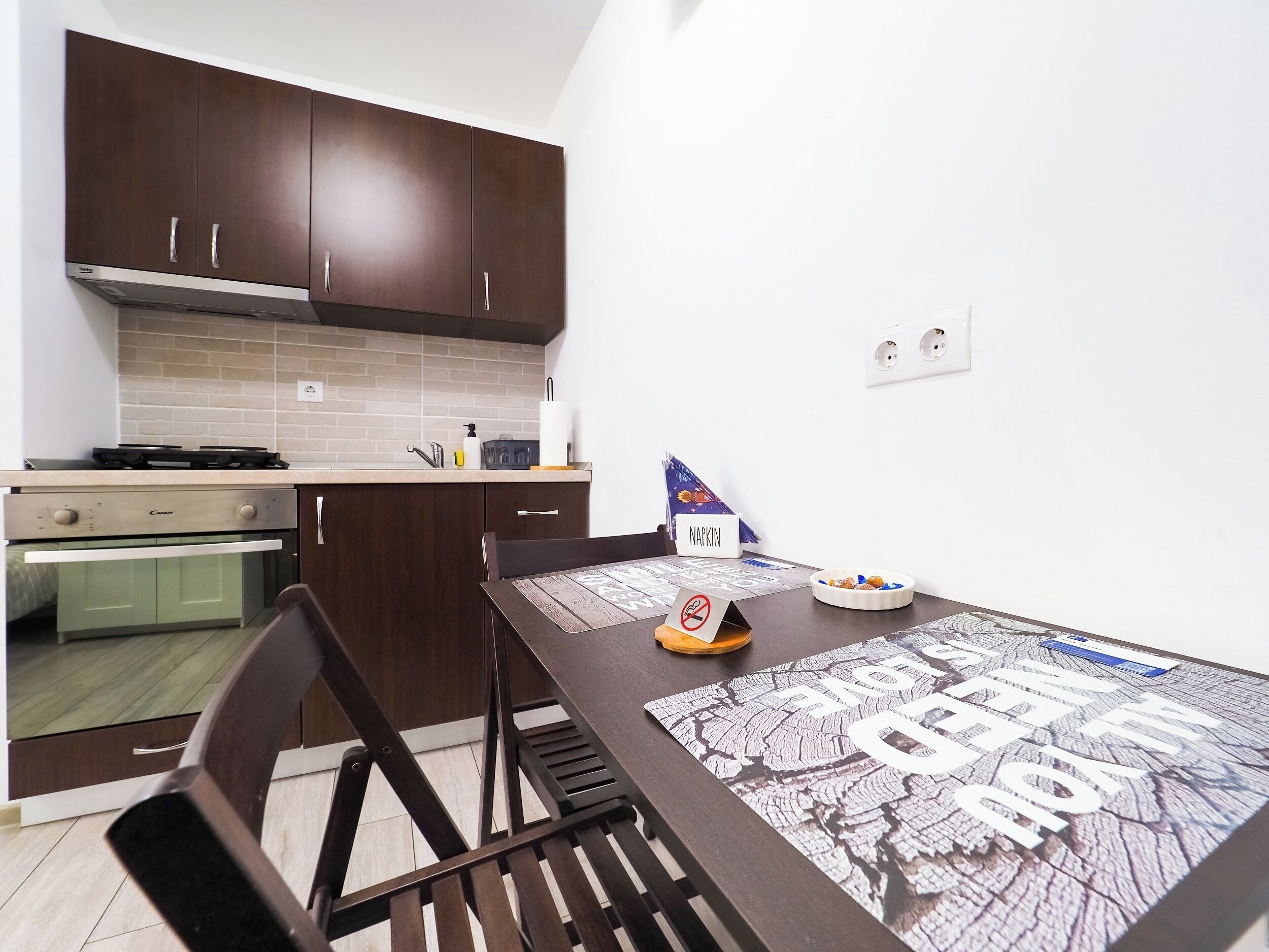 A compact kitchen with dark wooden cabinets, a built-in oven, and a gas stove.