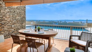 Un balcon avec un mur en pierre, une piscine et une table avec des chaises.