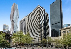 A modern urban area with tall buildings, including a prominent rectangular structure with horizontal lines and a curved glass building.