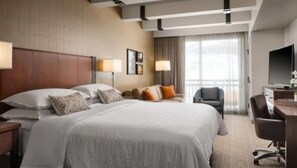 Relax in comfort with a large bed, desk, and flat-screen TV in this inviting space.