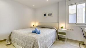 A bedroom with a bed, bedside tables, a window, and a wall-mounted shelf. - Apartment in Roses Near Rock Beach (Roses)