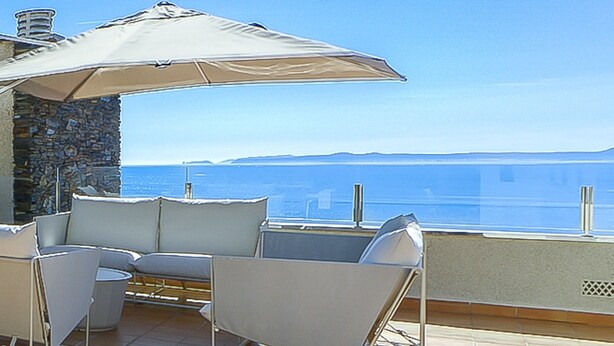 A terrace with outdoor seating and a view of the sea. - Apartment in Roses Near Rock Beach (Roses)