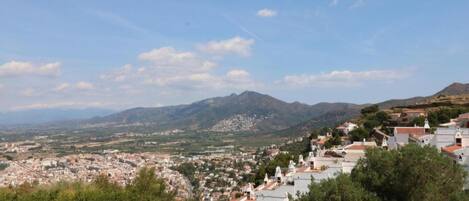 A town with white buildings and a mountain range in the background.
