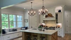 A spacious kitchen with a large island, bar stools, a chandelier, and a farmhouse sign. - Private Equestrian estate in Aiken, SC. Only 30 miles to Augusta National.  (Aiken)