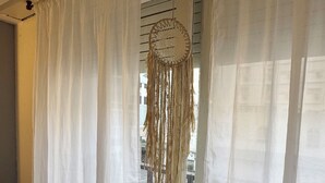 A room with white curtains, a dreamcatcher hanging by the window, and a tiled floor. - Rincón del Edén ~ Apartment in front of the casino and 1 block from the sea ☀️ (Mar del Plata)