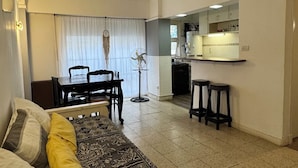A compact living space with a bed, a dining table, and a kitchenette in the background. - Rincón del Edén ~ Apartment in front of the casino and 1 block from the sea ☀️ (Mar del Plata)