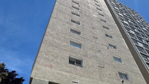 A tall building with a modern design, featuring a glass entrance and a sign indicating it is a public building. - Rincón del Edén ~ Apartment in front of the casino and 1 block from the sea ☀️ (Mar del Plata)