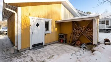 Guests can enjoy a warm welcome at this cozy abode with a small porch and a firewood storage area.