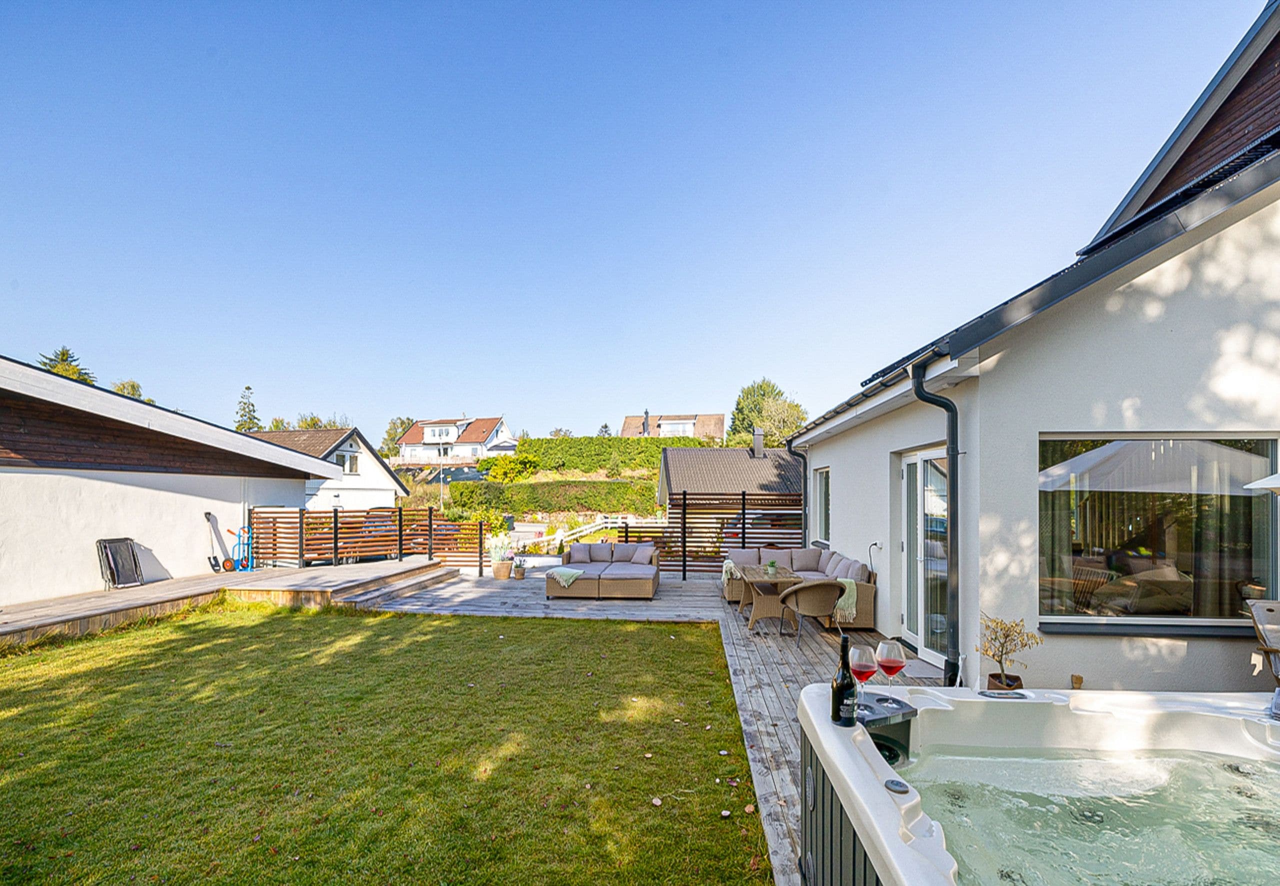 Une maison moderne dotée d’un patio, de mobilier d’extérieur et d’un jacuzzi.