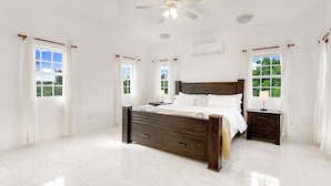 A spacious bedroom with a large bed, two bedside tables, a ceiling fan, and large windows with curtains. - Spacious 3-bedroom, 2-bathroom apartment with AC in The Valley (The Valley)