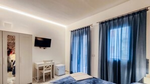 A hotel room with a bed, a desk, a chair, a TV, and a wardrobe. - A 10-minute walk from the historic center and Arab-Norman route (Palermo)