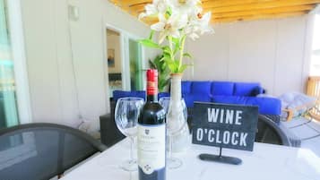 A table with a bottle of CECCHI wine, a vase with white flowers, and a sign reading "WINE O'CLOCK".