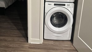 Een kleine wasruimte met twee Whirlpool wasmachines boven elkaar.