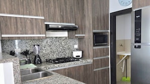 Eine moderne Küche mit Granitarbeitsplatten, Edelstahlgeräten und Holzsäulen.