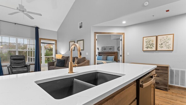 A modern kitchen with a large island, a built-in dishwasher, and a ceiling fan. - Gorgeous Golf Views Condo in the heart of Branson (sleeps 8) (Branson)