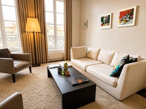 Uma sala de estar moderna com sofá, poltrona, mesa de centro e obras de arte na parede.