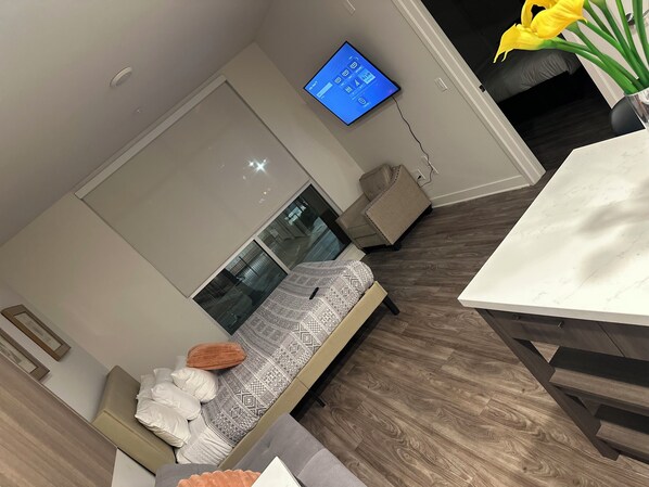 A modern living room with a sofa, a coffee table, and a TV mounted on the wall.
