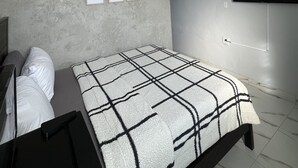 A bedroom with a bed, a TV mounted on the wall, and a wall-mounted power outlet. - Molinos House 3 (Santa Isabel)